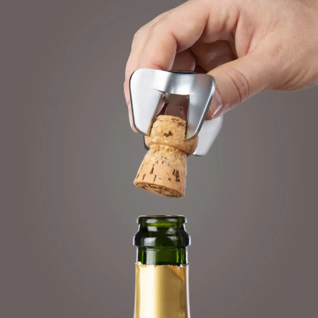 Abridor seguro para botellas de espumantes y champagne en acero, ideal para eventos y celebraciones.