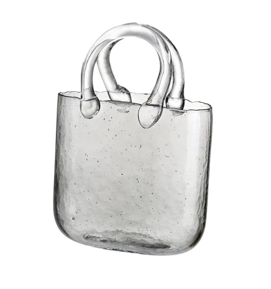 Cartera de vidrio vacía con diseño minimalista, ideal para servir tragos con un toque innovador y creativo.