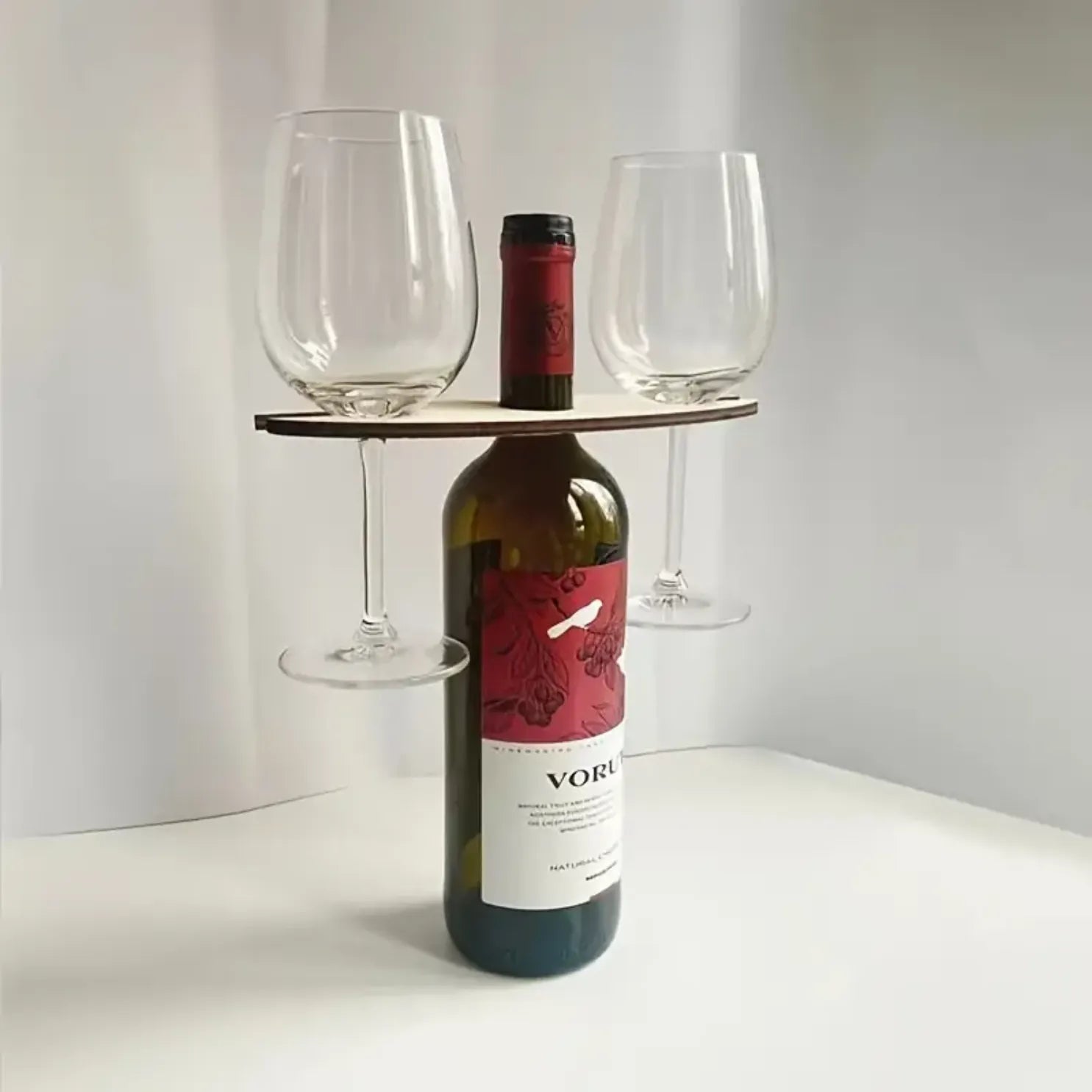 Soporte de madera para botellas de vino, permite sostener hasta 2 copas de forma elegante y práctica.